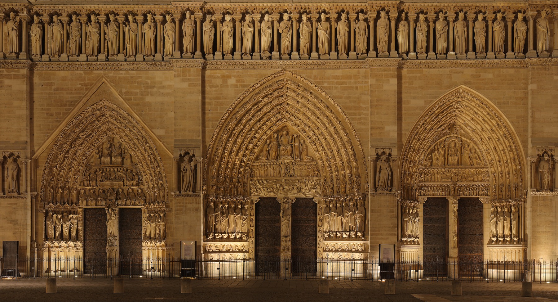 The lower west facade of Notre-Dame Cathedral in Paris with the three sculpted portals.