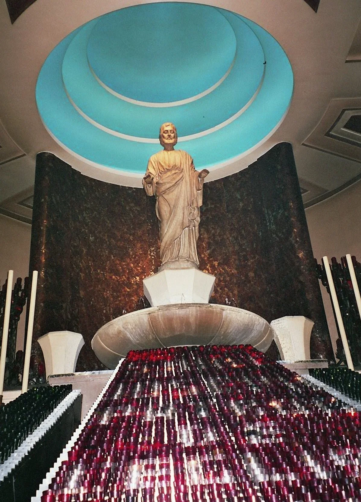 A statue of Saint Joseph above votive candles inside the Oratory’s Votive Chapel.