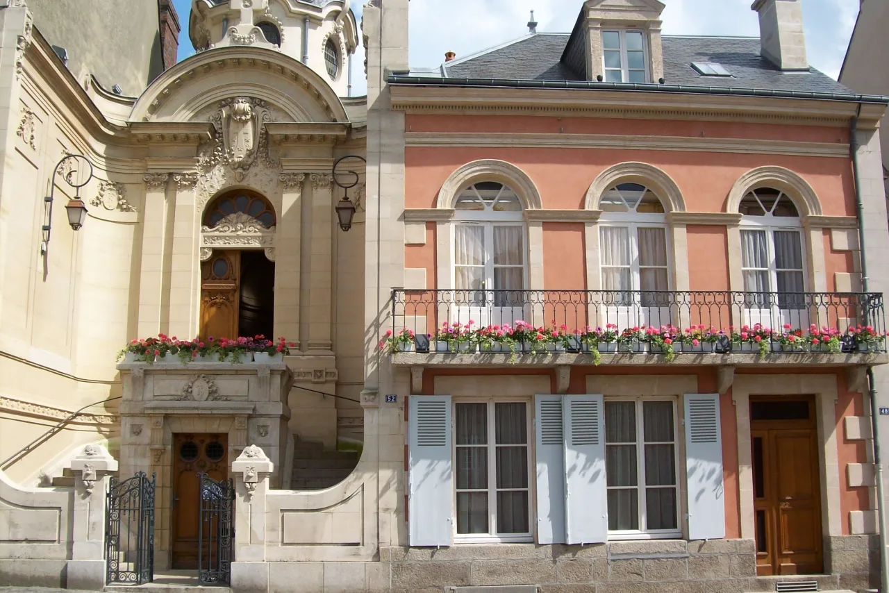 The street front of the Martin family house at 50 rue Saint-Blaise in Alençon, its shuttered windows and flowered balcony beside the entrance to the adjoining chapel.