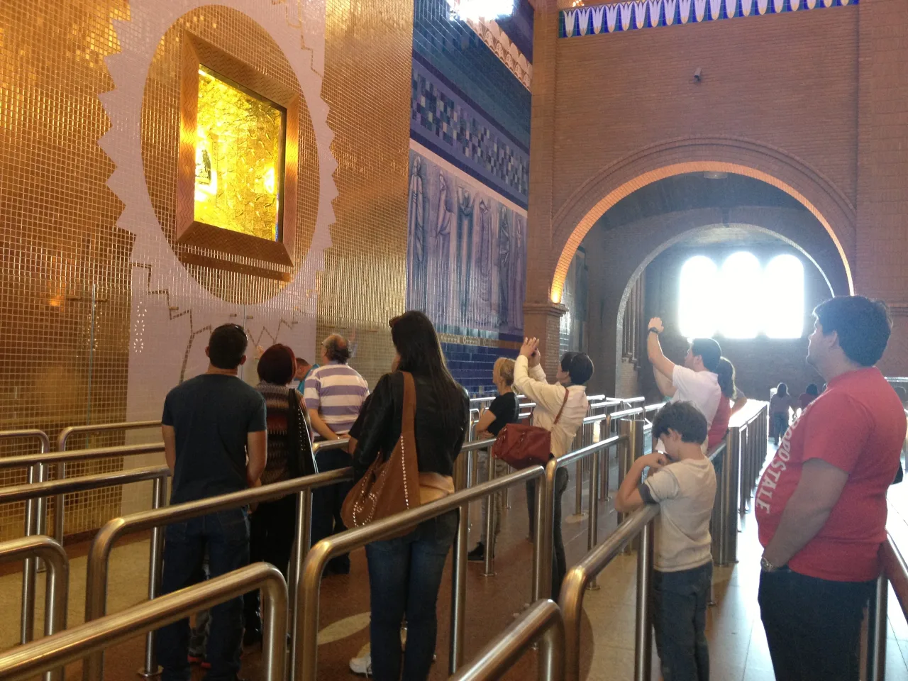 Pilgrims approaching the niche of Our Lady of Aparecida inside the basilica.