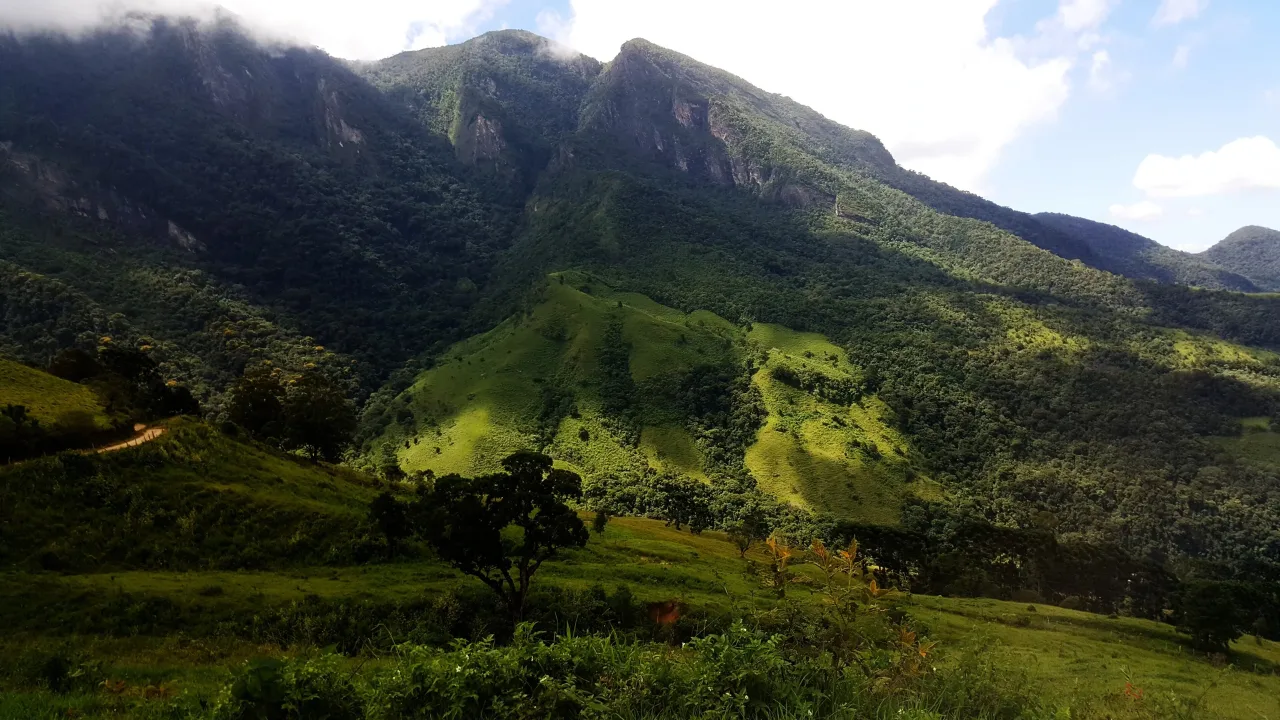 Green mountain slopes on the Caminho da Fé descent from Campos do Jordão toward Aparecida.