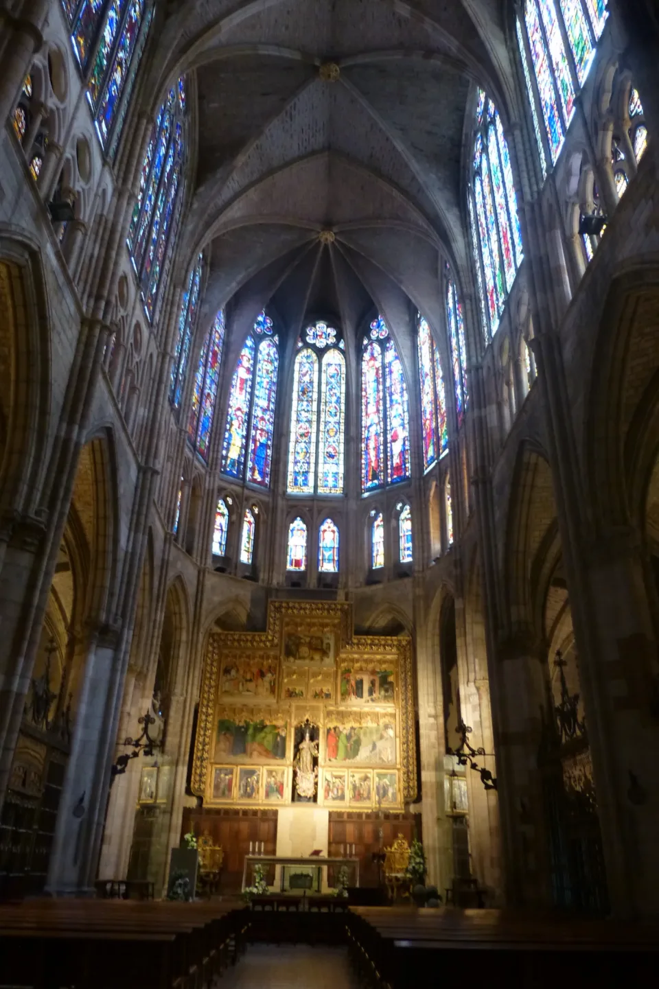 The nave of León Cathedral looking toward the high altar, its upper walls filled with stained glass.