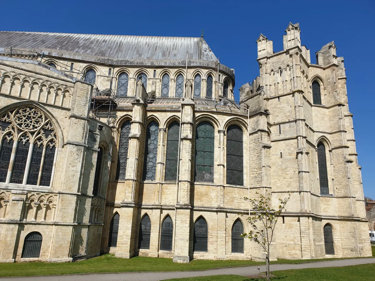 The eastern end of Canterbury Cathedral under a clear sky: the tall windows of the Trinity Chapel and, to the right, the round tower of the Corona.