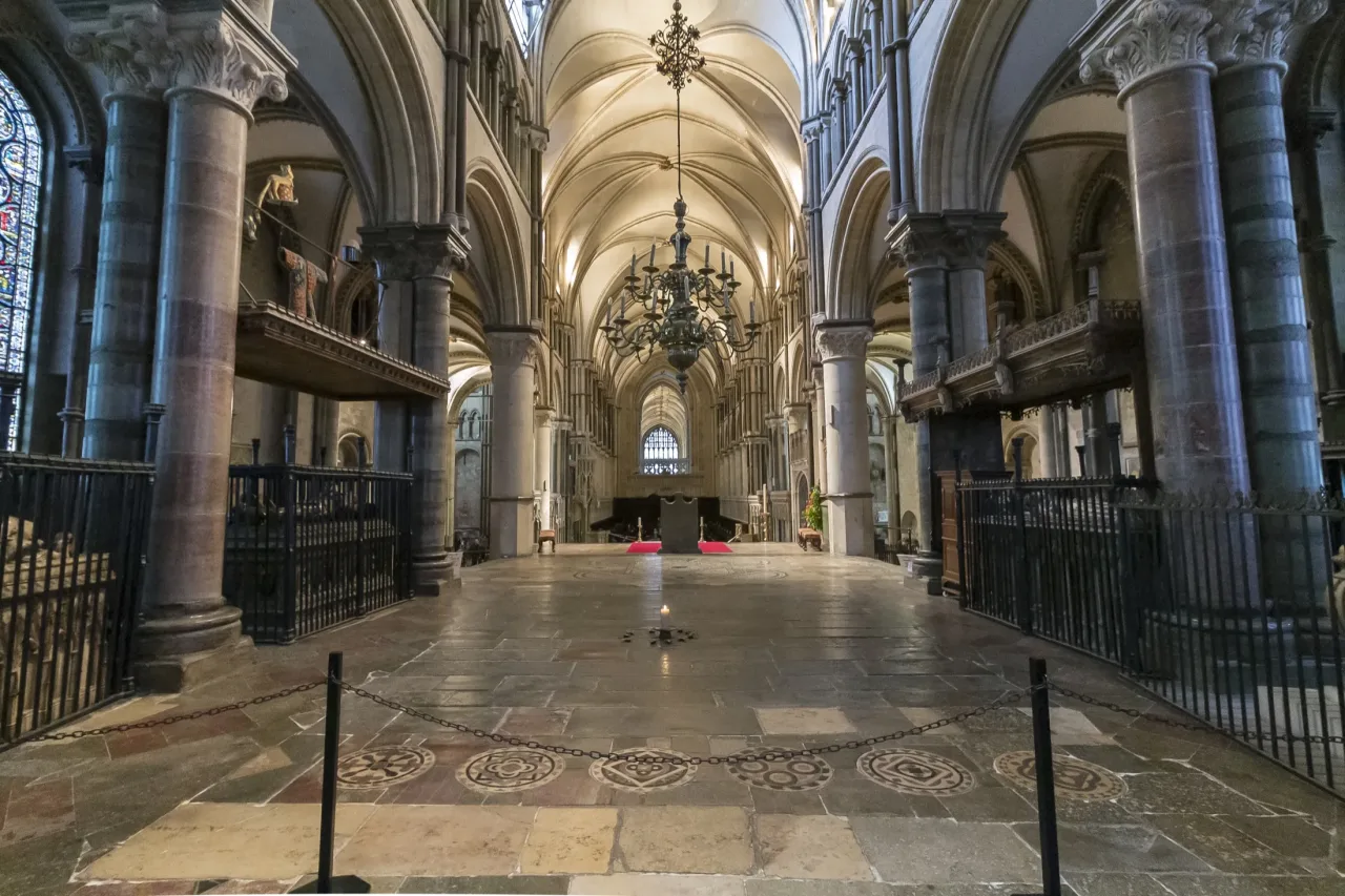 The Trinity Chapel of Canterbury Cathedral looking west, with a single candle burning on the stone floor where Becket's shrine once stood.