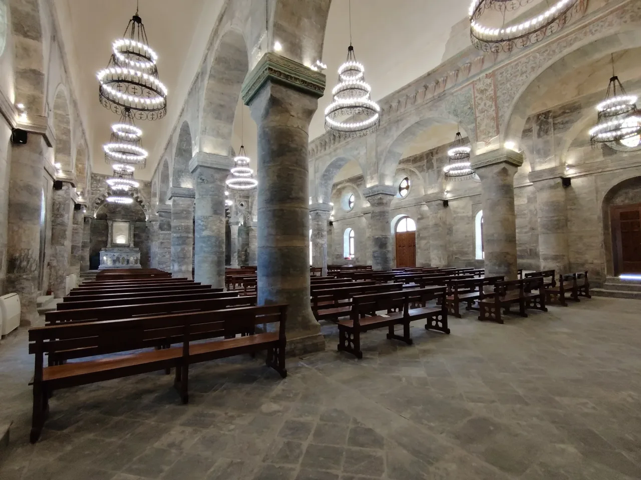 Restored interior of Al-Tahera Syriac Catholic Church in Mosul, with alabaster columns and decorative arches.