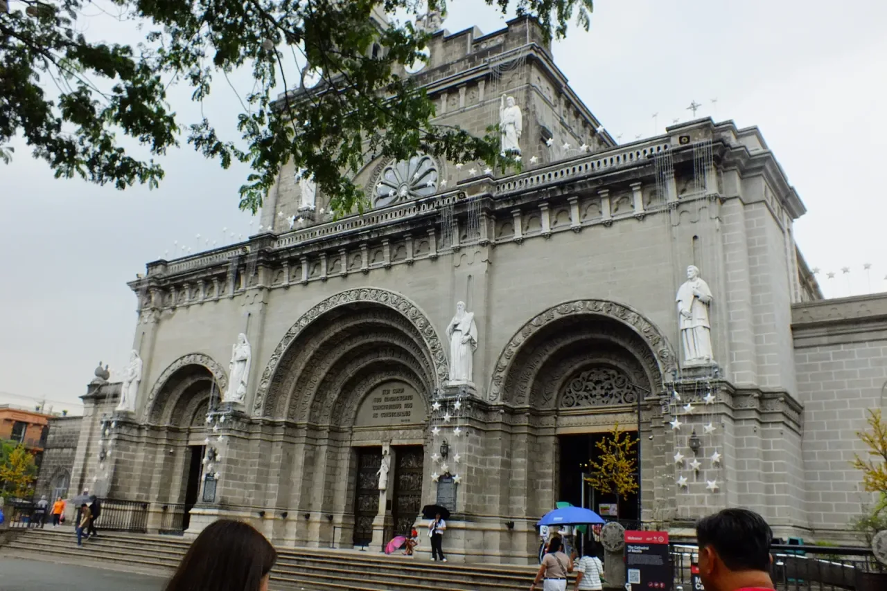 The three arched portals and stone facade of Manila Cathedral.