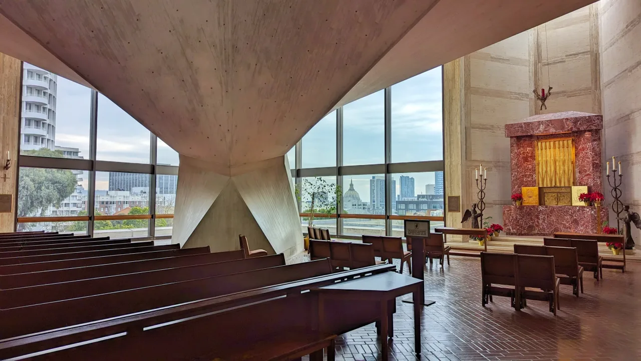 The Blessed Sacrament chapel at St. Mary's Cathedral, with a red marble tabernacle wall and full-height windows showing the city outside.