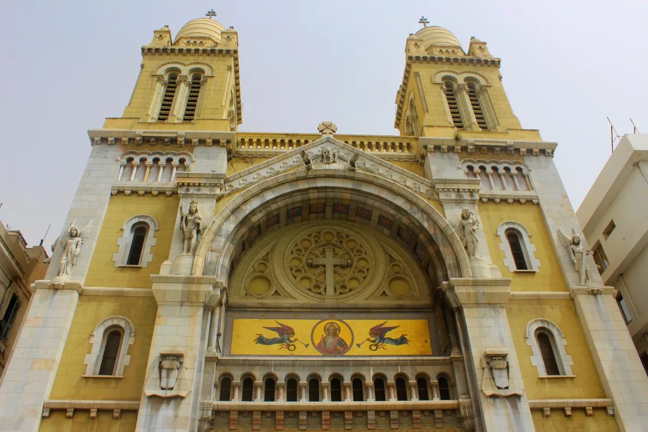The twin-towered facade of the Cathedral of Saint Vincent de Paul in Tunis, with its mosaic of Christ above the entrance arch.