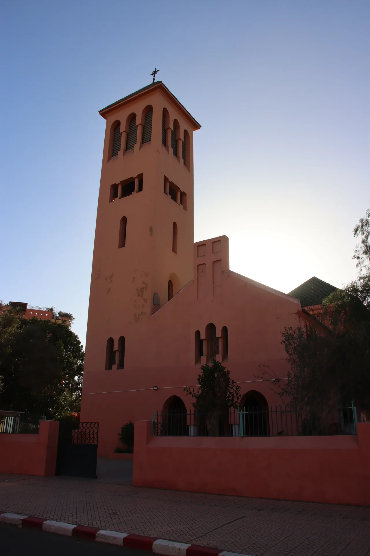 The ochre bell tower and body of the Church of the Holy Martyrs in the Gueliz quarter of Marrakech, in late afternoon light.