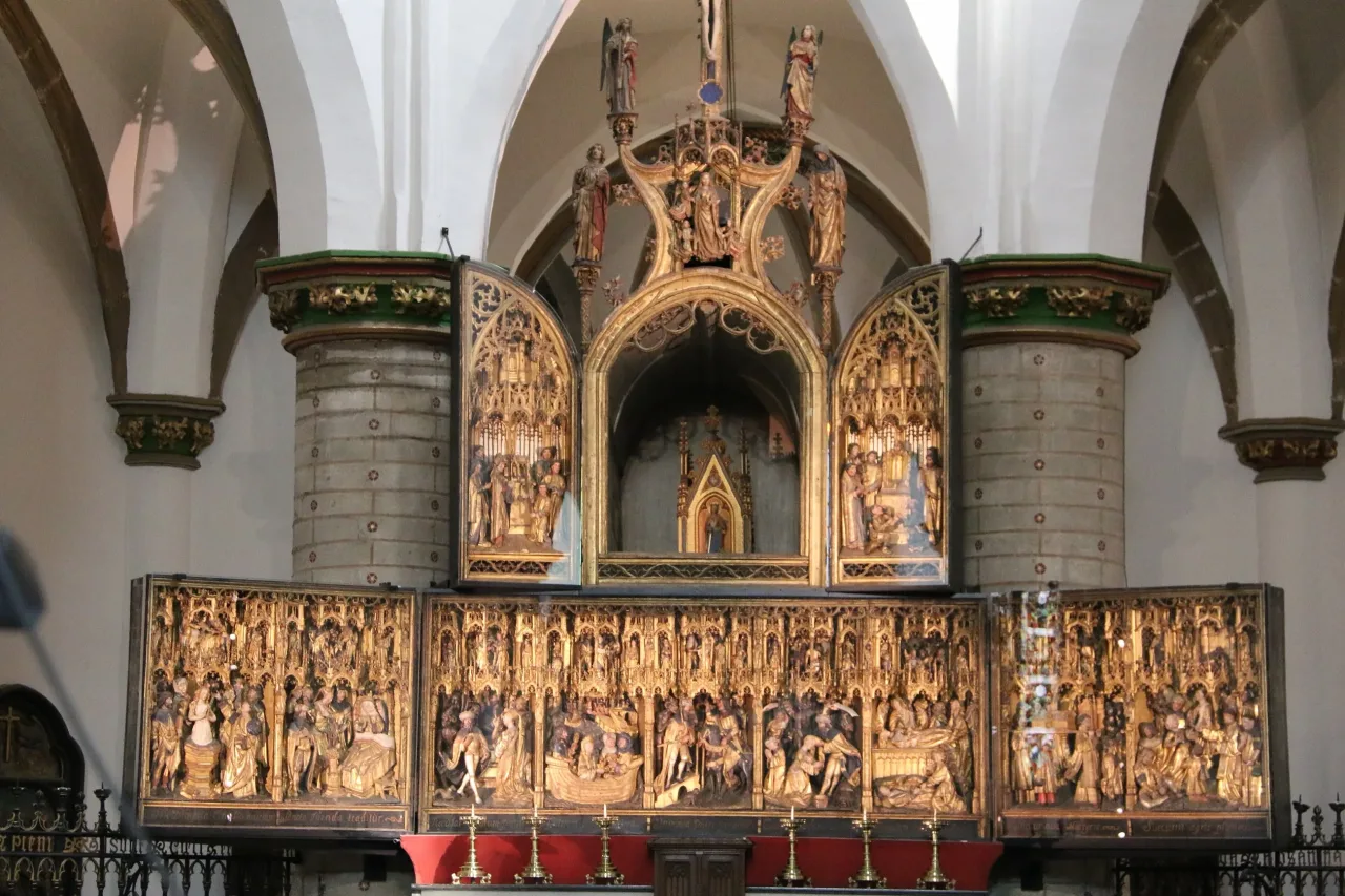 The Saint Dymphna retable of 1515 on the old high altar at Geel, with a gilded shrine standing in the arched niche above it.