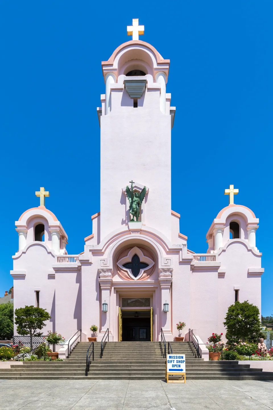 The facade of St. Raphael parish church in San Rafael, with a bronze figure of the archangel in a niche above the door.