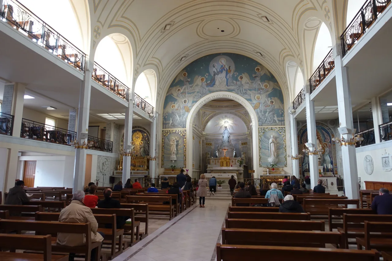 The nave, galleries, high altar, and Marian mosaics inside the Chapel of Our Lady of the Miraculous Medal in Paris.