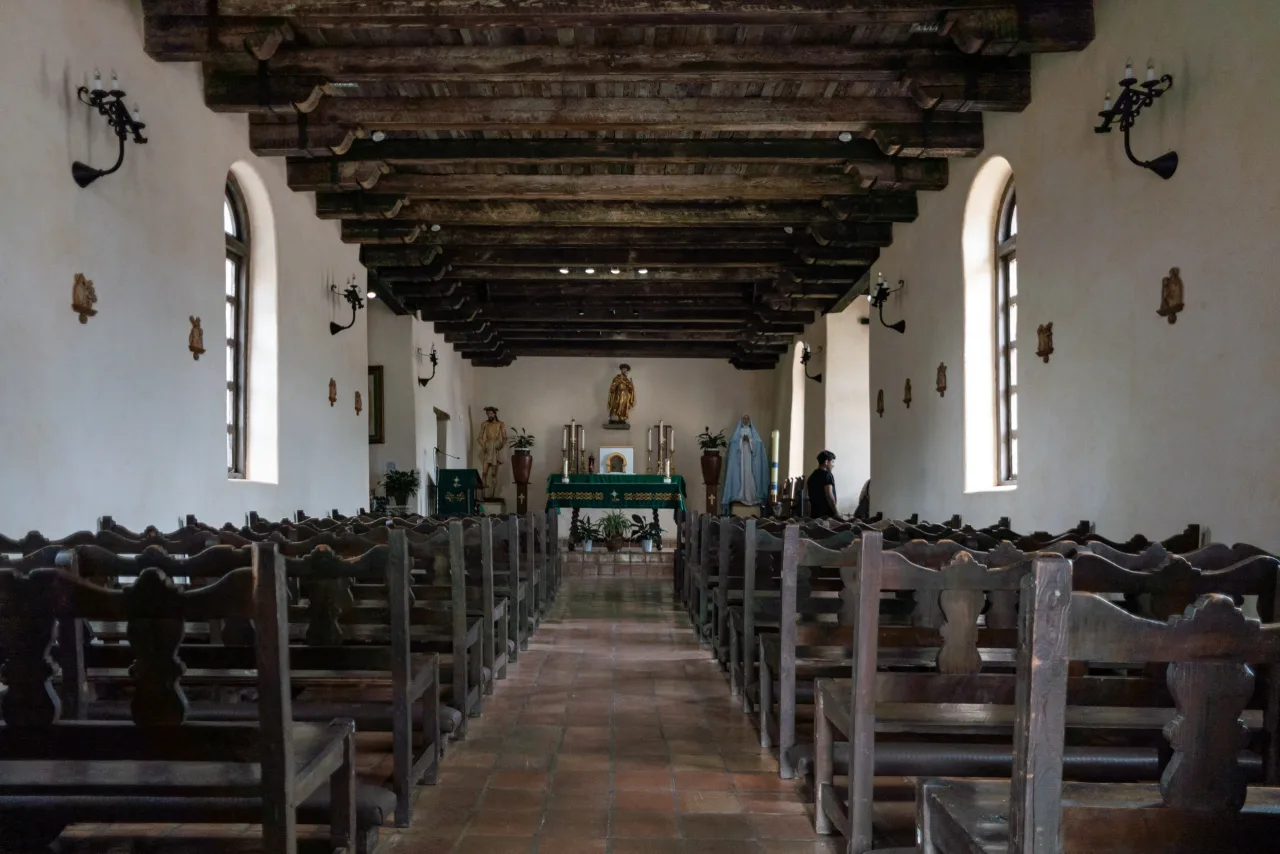 The simple nave and sanctuary inside Mission Espada's stone church.