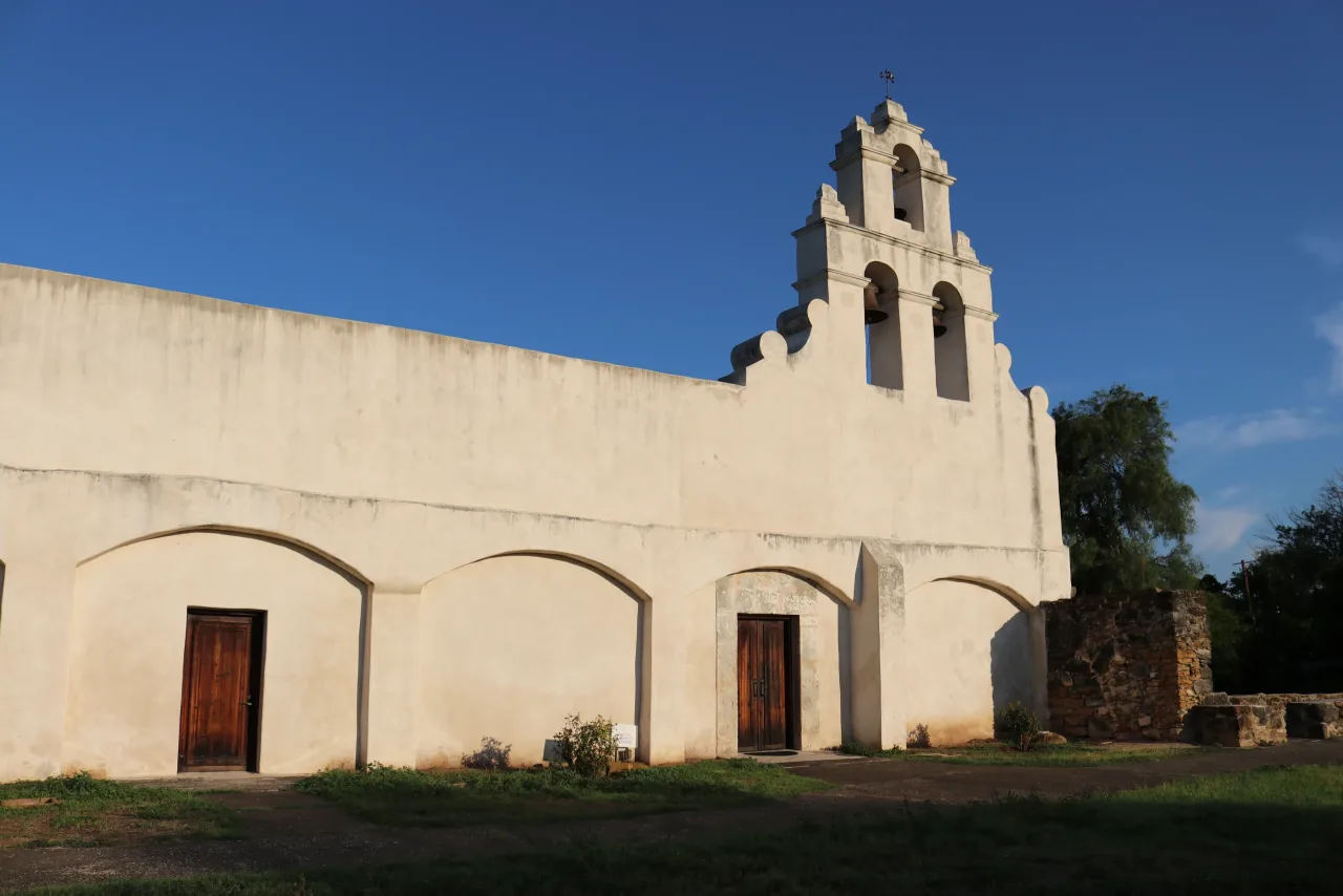 The white stone church and three-bell gable at Mission San Juan Capistrano in San Antonio.