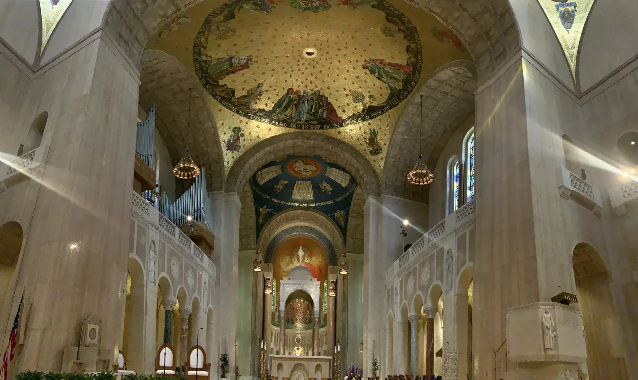The mosaic-lined nave of the National Shrine of the Immaculate Conception looking toward the baldachin and sanctuary.