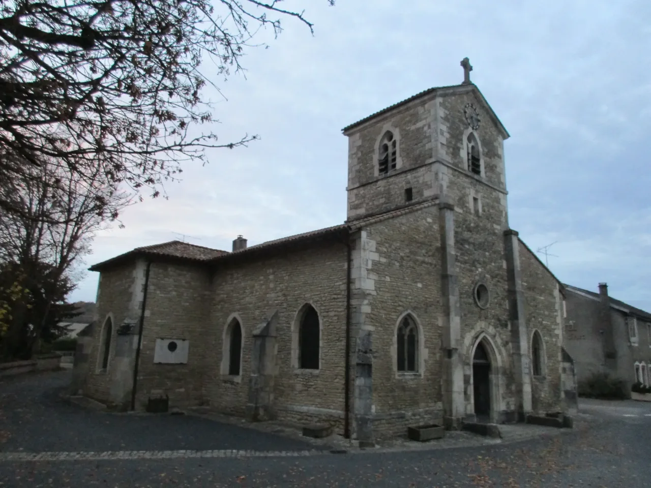 The church of Saint-Remy at Domremy-la-Pucelle seen from the road, a small stone church with a square tower and lancet windows.