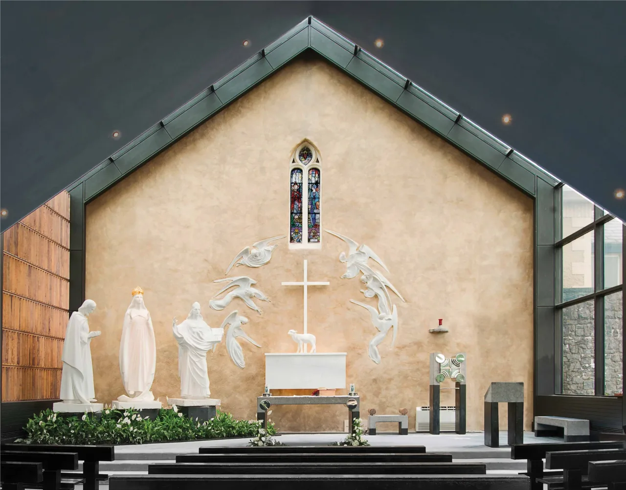 The Apparition Chapel at Knock, with its stained window and sculpted tableau of Our Lady, Saint Joseph, Saint John, and the Lamb.