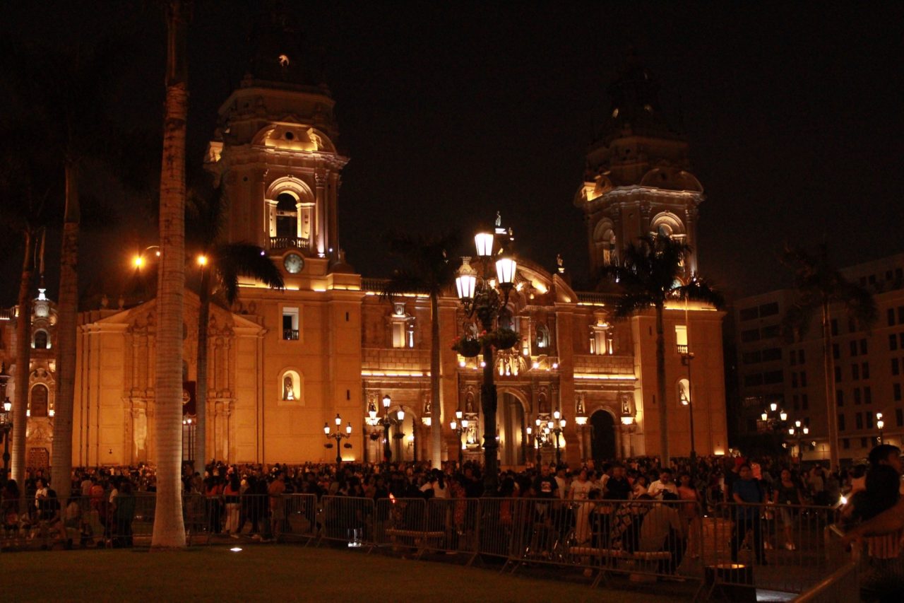 The facade of Lima Cathedral on the Plaza Mayor lit at night.
