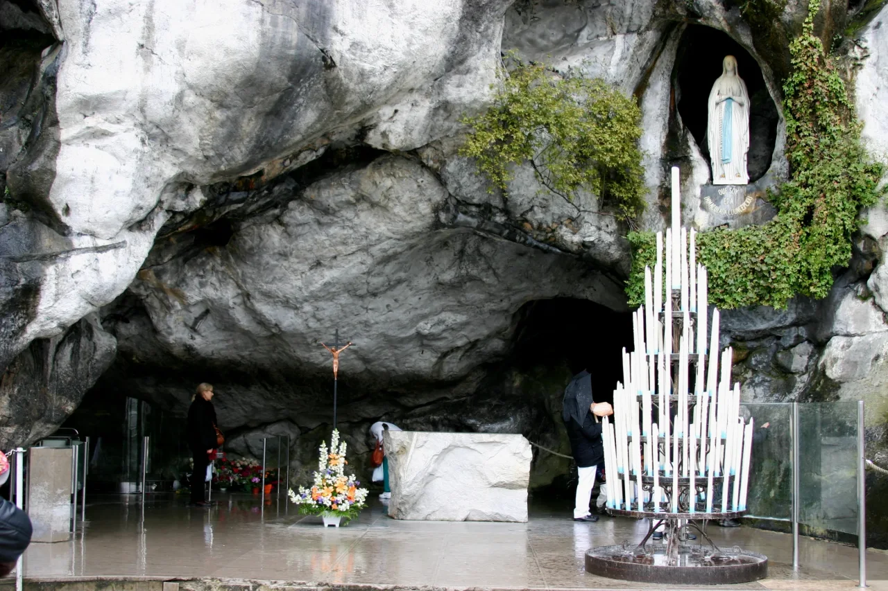 Pilgrims gathered in prayer at the Grotto of Massabielle in Lourdes.