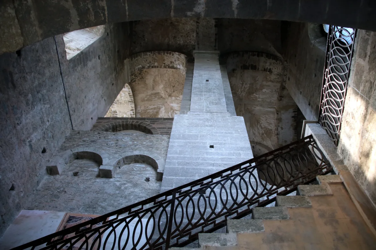 Stone steps and iron railings climb around the enormous central pier in the Staircase of the Dead.