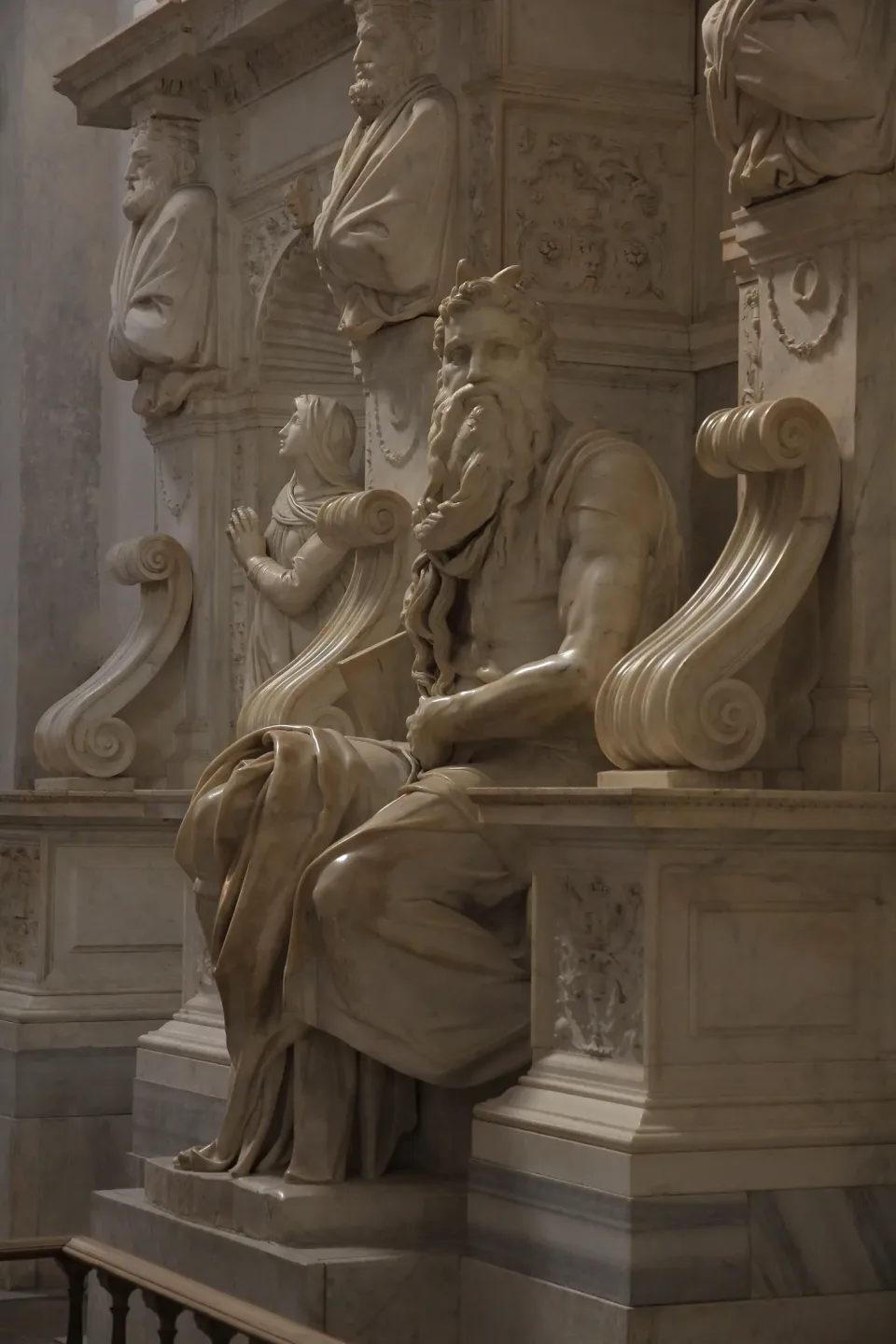 Michelangelo's marble Moses, seated and horned, holding the tablets of the Law, in the tomb of Julius II.
