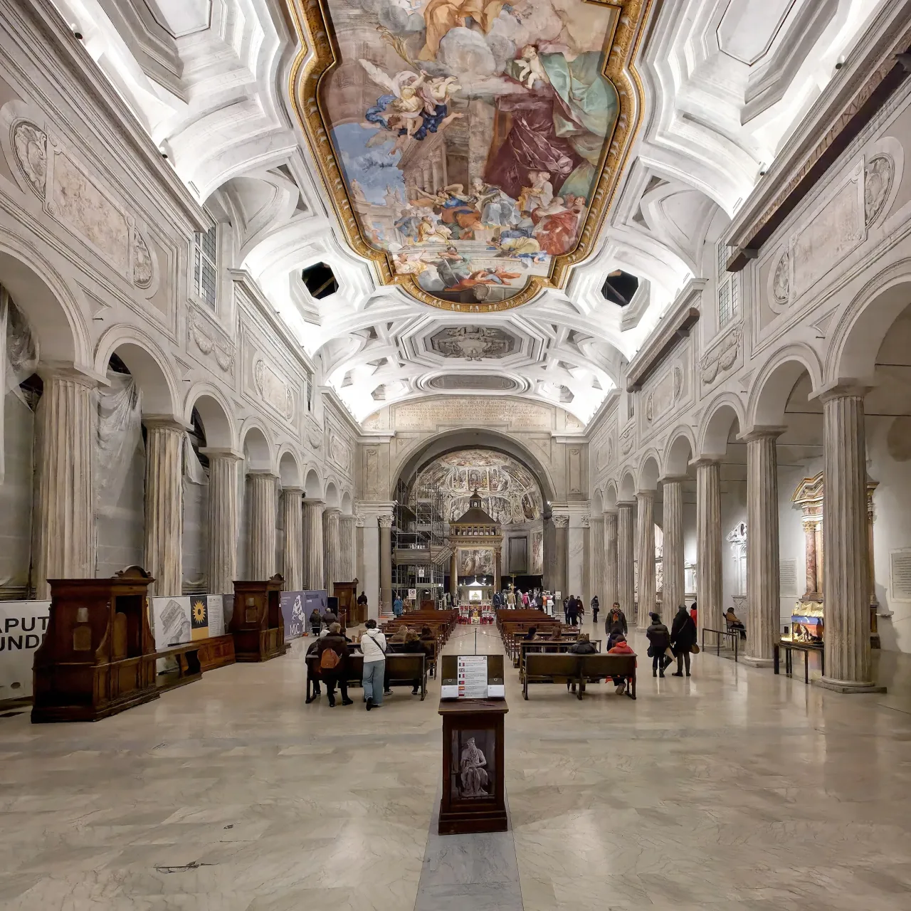 The nave of San Pietro in Vincoli: two rows of ancient Doric columns under a painted coffered ceiling, leading to the apse.