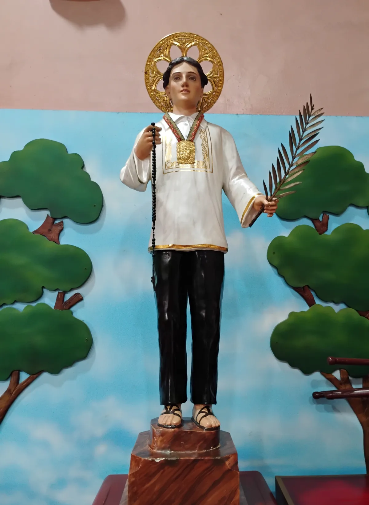 Devotional statue of Saint Lorenzo Ruiz in Binondo Church, holding a Rosary and martyr’s palm.
